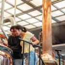 UC Davis students Fermin Barbosa and Tali Cooper help brew their winning beer recipe at Sudwerk Brewing Co. in Davis. The team won the 2024 UC Davis Iron Brew Competition with their "Brew La-La," a Belgian blonde ale. Photo by: Katherine Yanogacio, Sudwerk Brewing Co.
